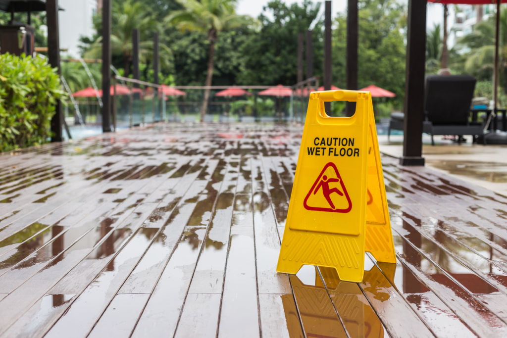 Yellow wet floor warning sign on the floor in hotel